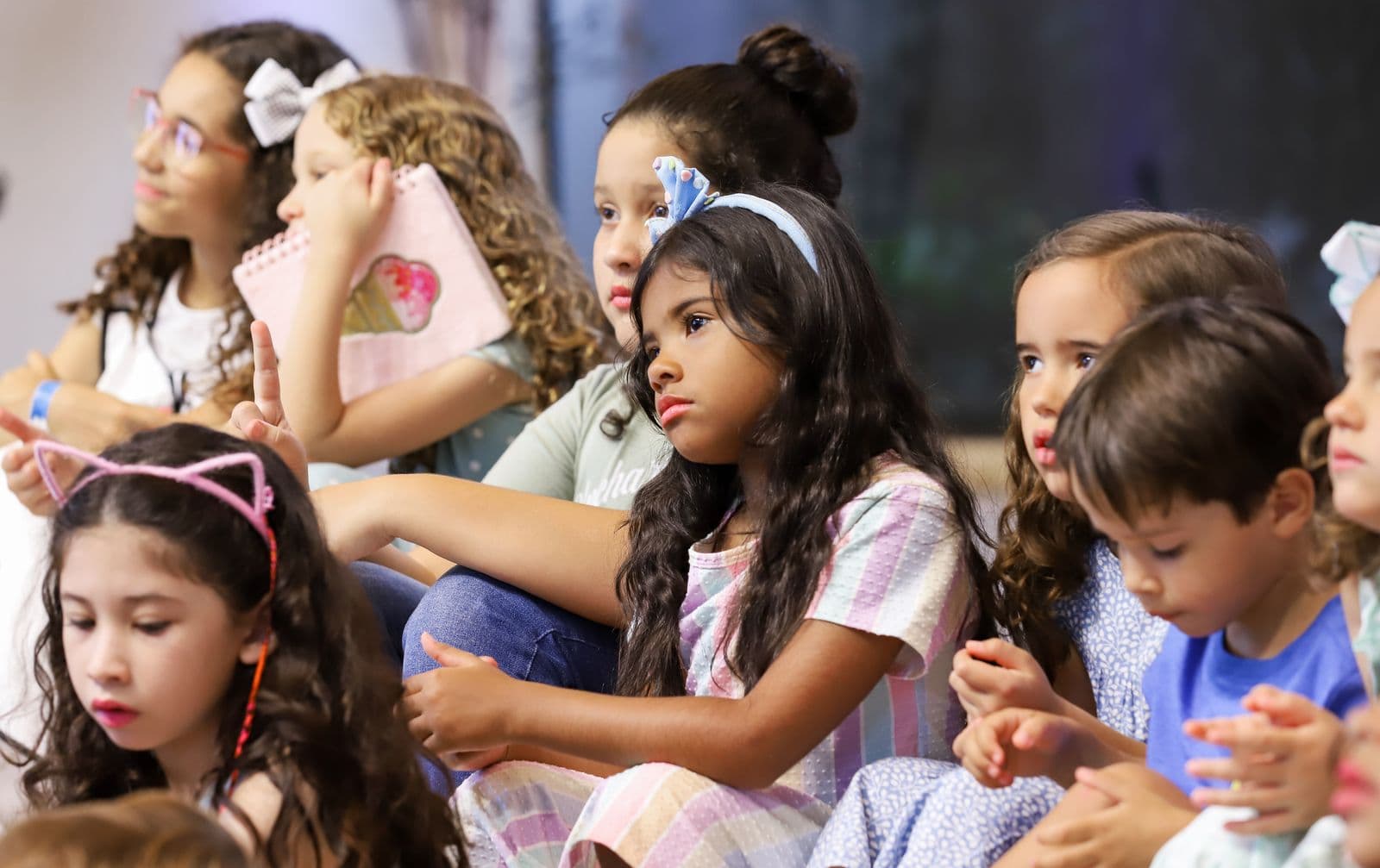 Children seated together in a classroom and listening closely