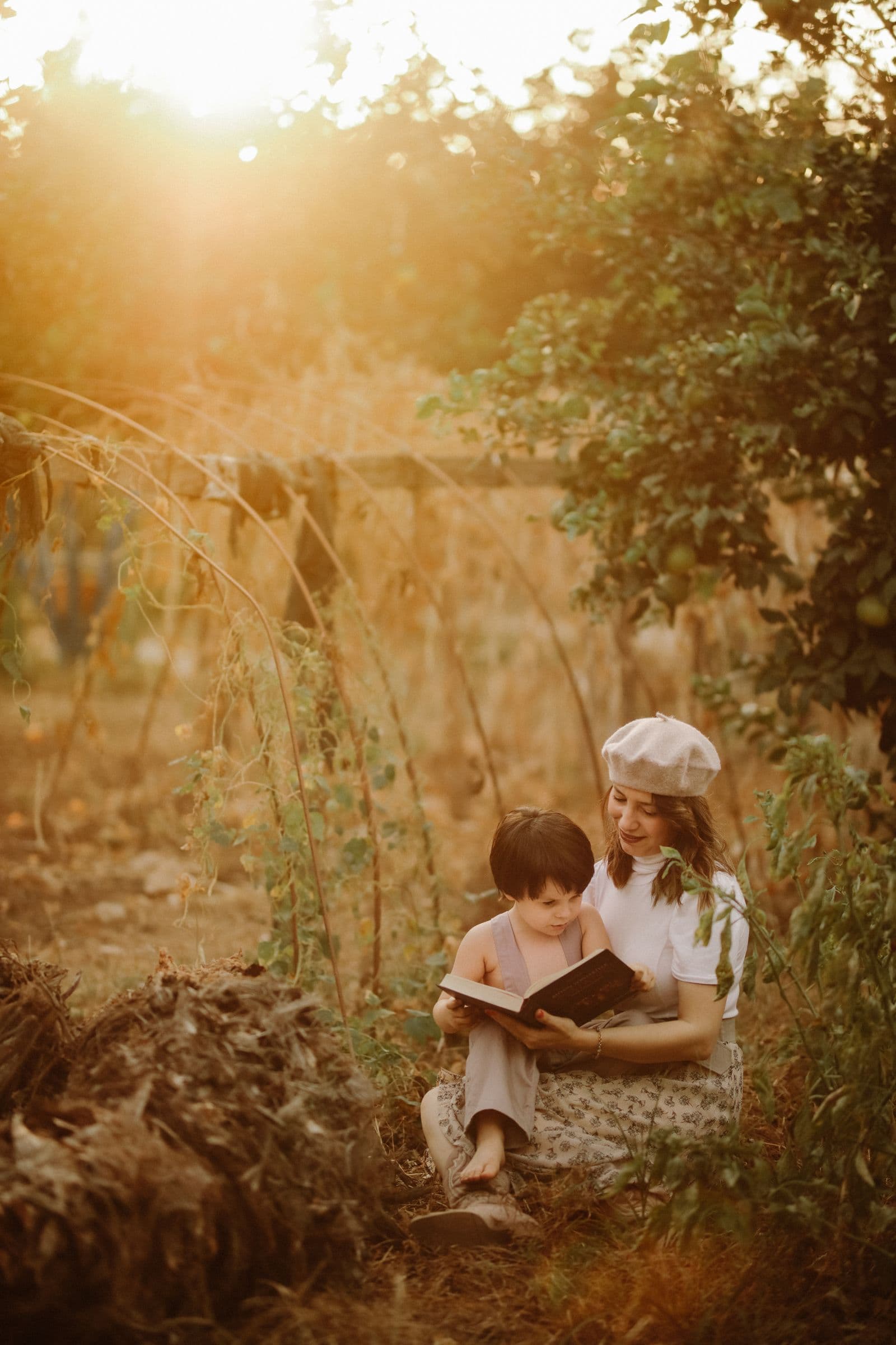 A caregiver and child reading together outdoors