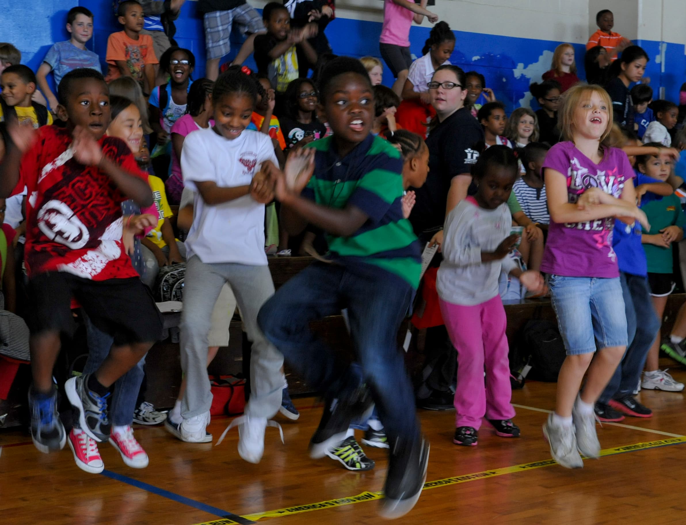 Children and youth moving together during an indoor gym activity