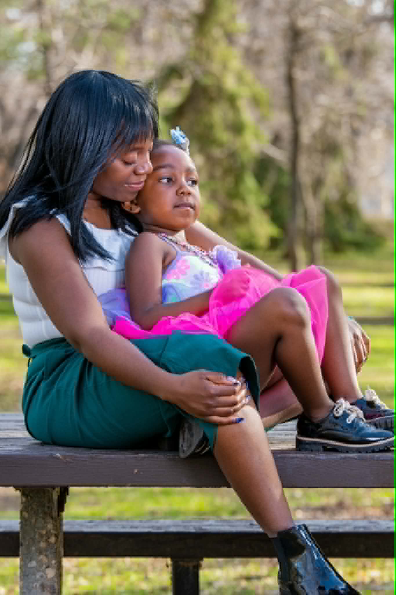A caregiver sitting with a child outdoors