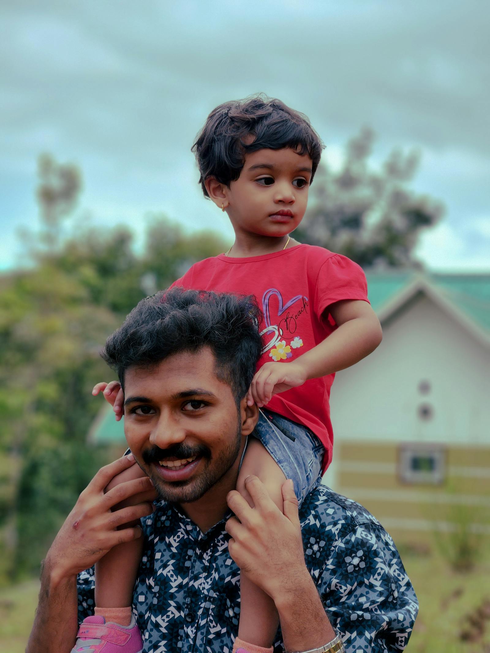 A parent carrying a child outdoors