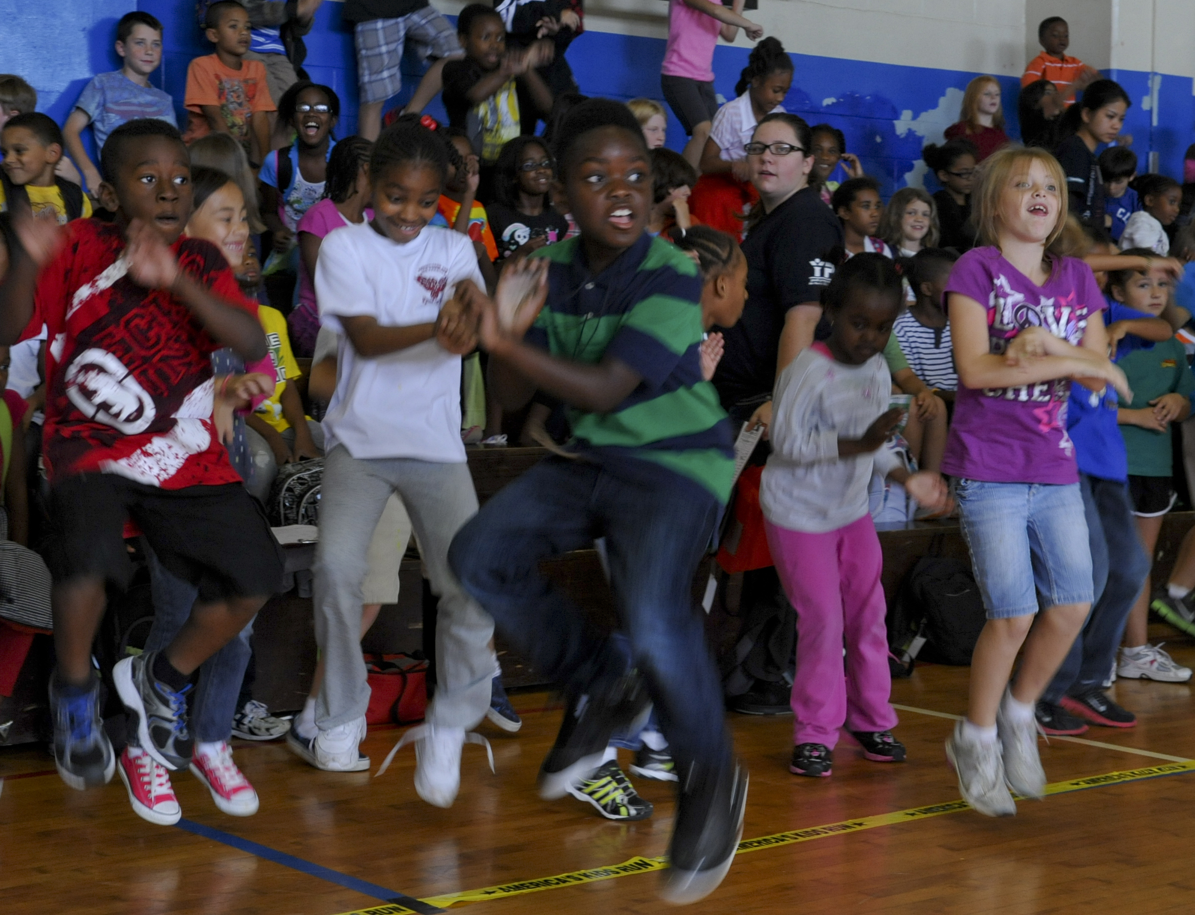 Children and youth moving together during an indoor gym activity